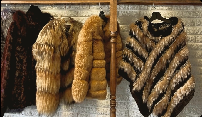 Fur coats and jackets hanging on a wooden rack